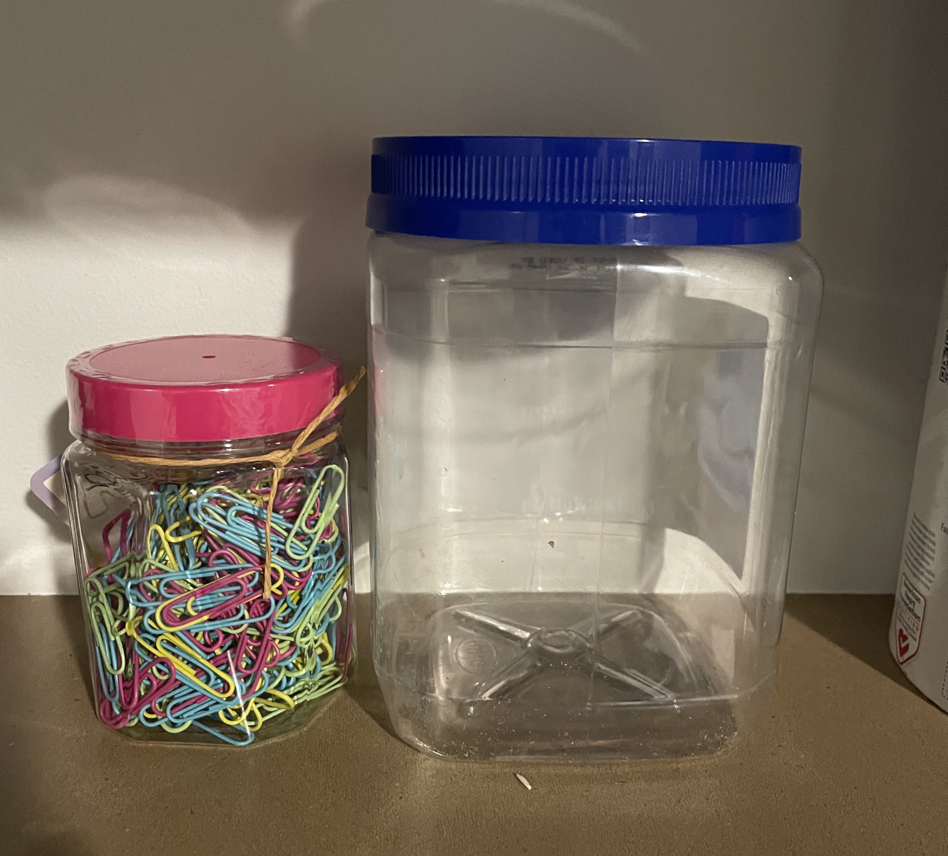Paper clip jar next to empty jar